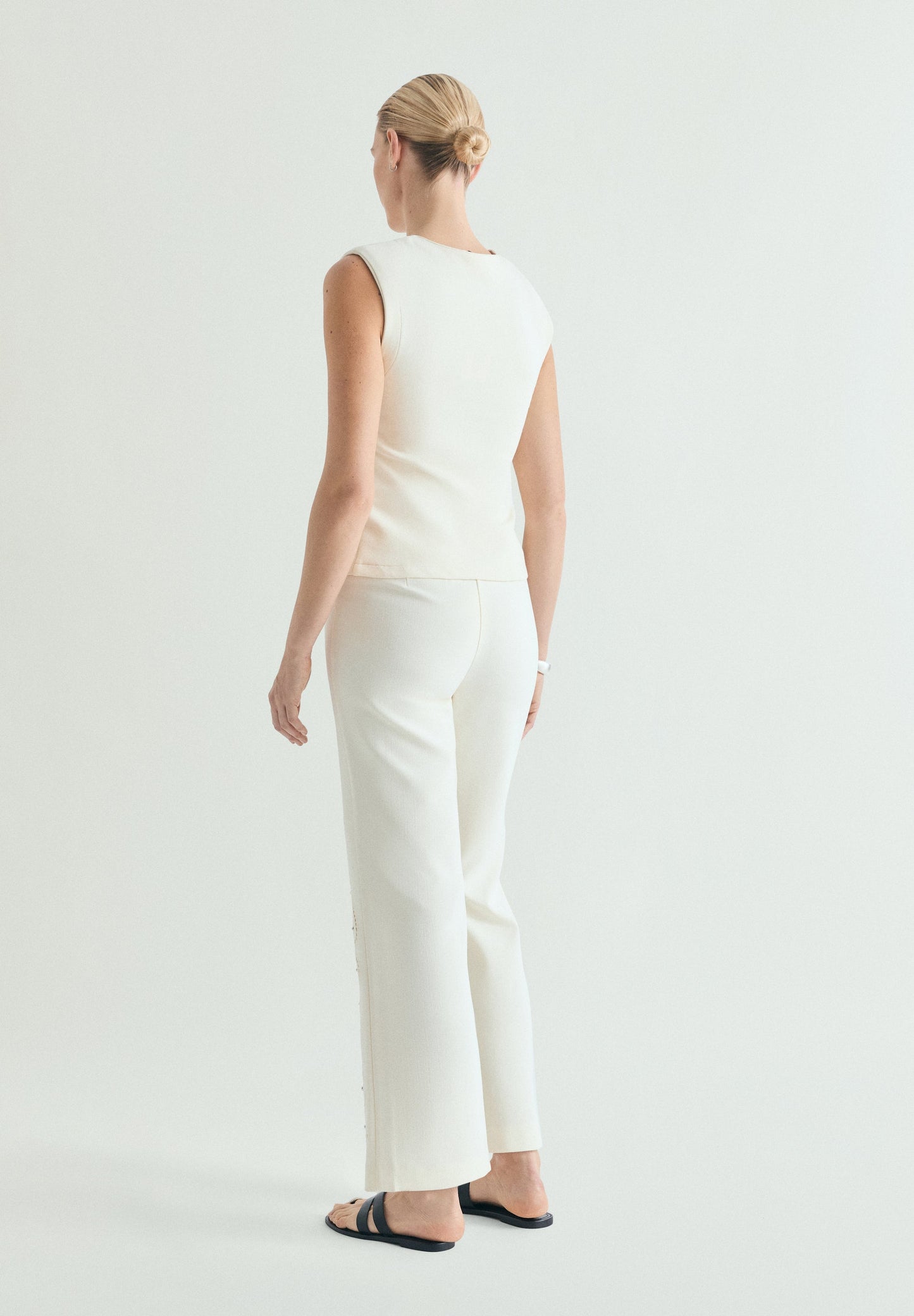 TROUSERS WITH PERFORATED DETAILS